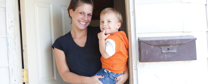 Mother holding smiling son in the doorway