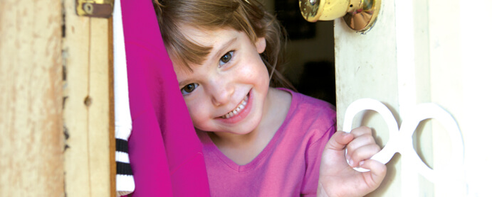 Little girl smiling in door frame