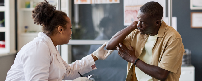 Dermatologist looking at patients elbow